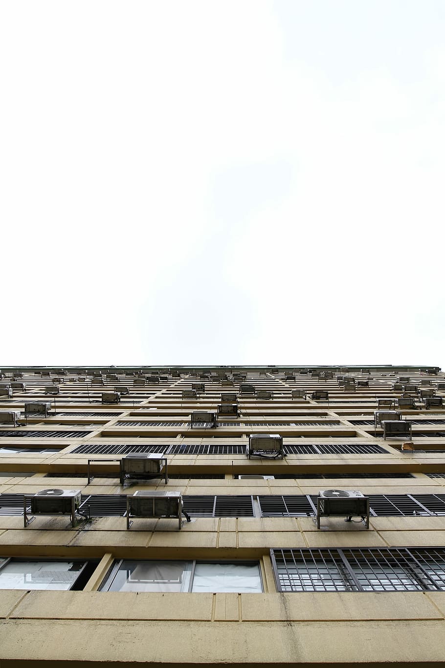 beige building in worm's eye view photography, worm view photography of brown high-rise building