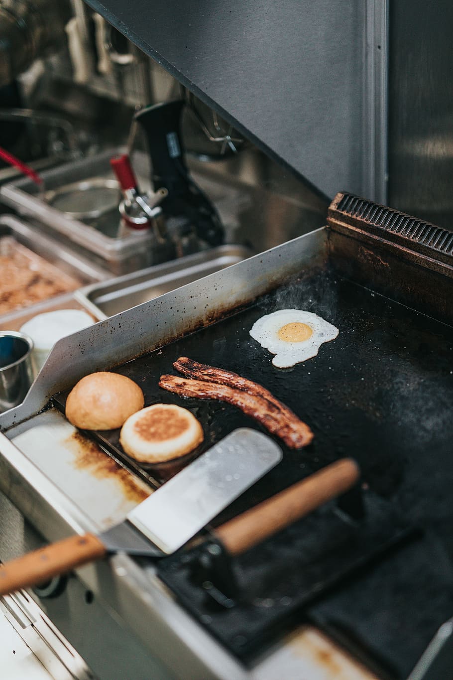 person cooking bacon, egg, and bread, fried egg, sausage, and buns HD wallpaper