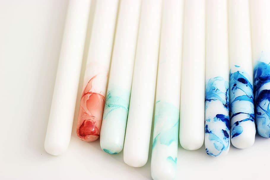 several white, blue, and red decorative taper candles, white-and-multicolored poles HD wallpaper