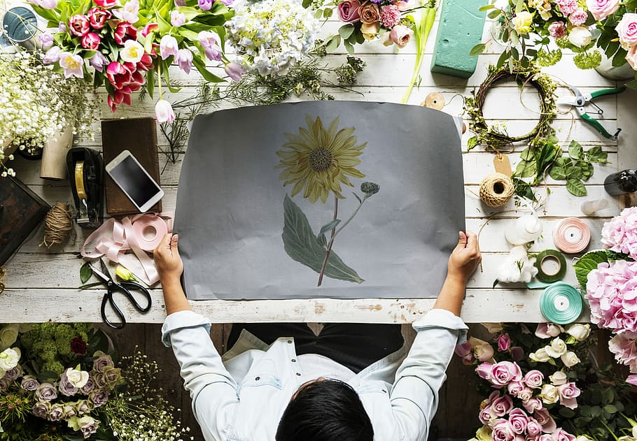 man holding sunflower painting front of table, flat lay, flowers HD wallpaper