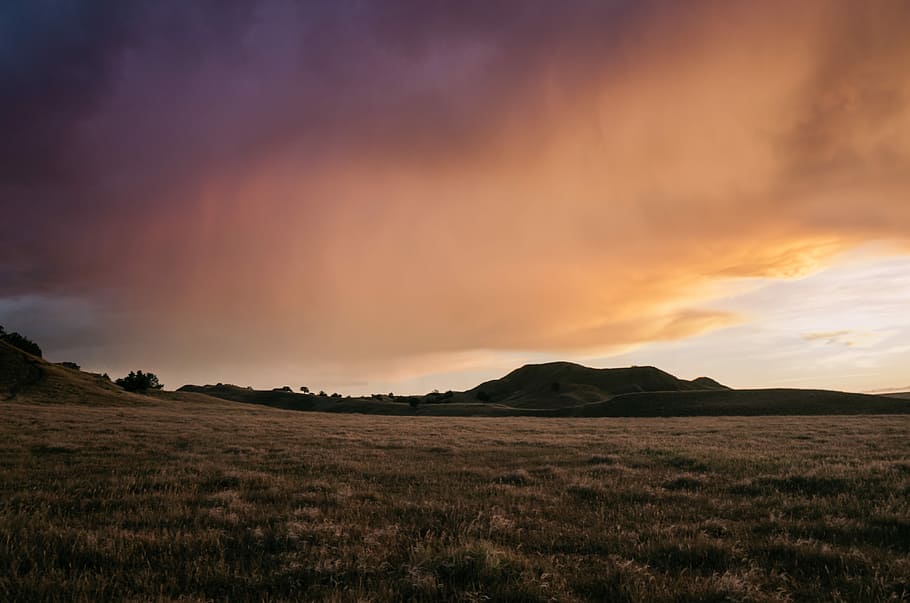 green grass near mountain under orange clouds, mountain ranges HD wallpaper