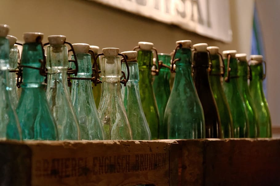 green glass bottles on brown wooden bottle holder, empty, case