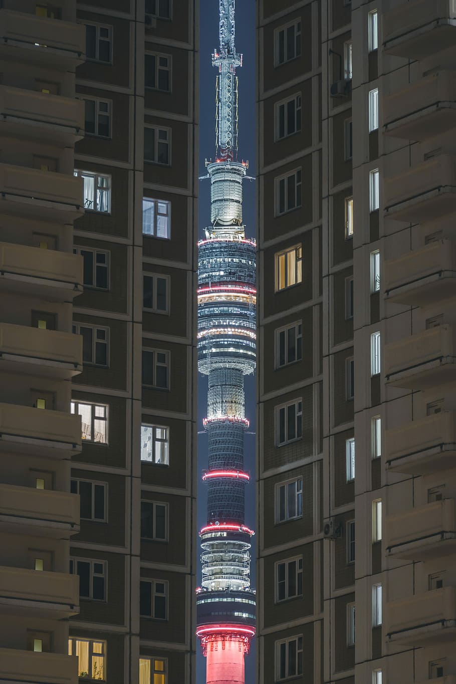 gray and white painted building, red and gray tower between buildings