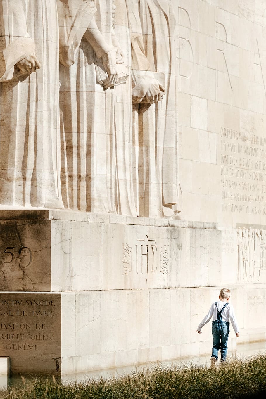 boy walking beside the statue, wall, stone, monument, carving HD wallpaper