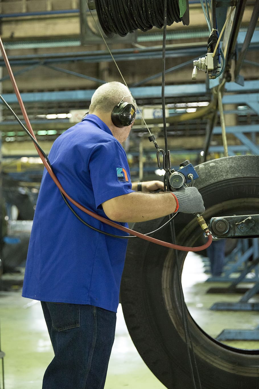 man wearing blue polo shirt holding tool and vehicle tire, work HD wallpaper