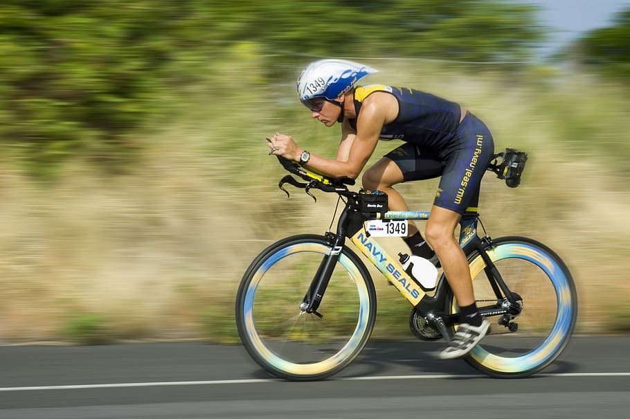 man wearing blue shorts riding bicycle, triathalon cycling racer