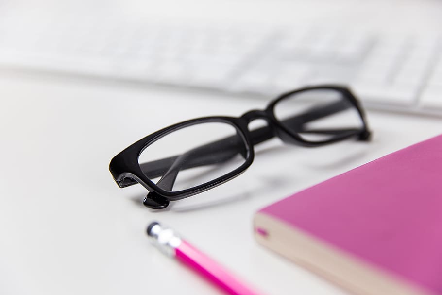 Reading glasses on a white office desk with computer keyboard, notepad and pencil, HD wallpaper