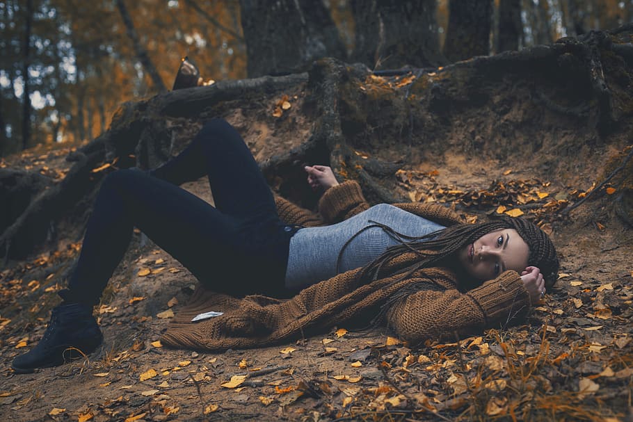 woman wearing brown cardigan and gray t-shirt with black sweatpants laying in forest during daytime, HD wallpaper