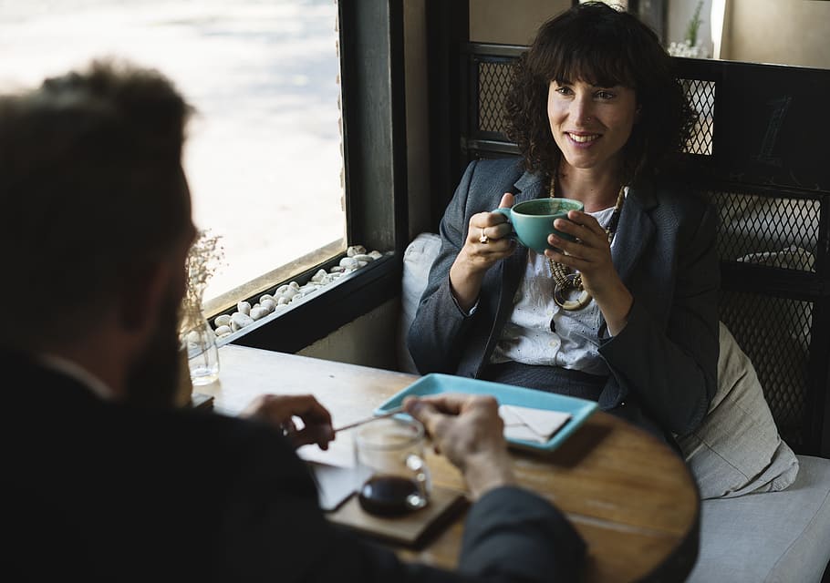 woman in black blazer sitting in front of a man, cup, restaurant HD wallpaper