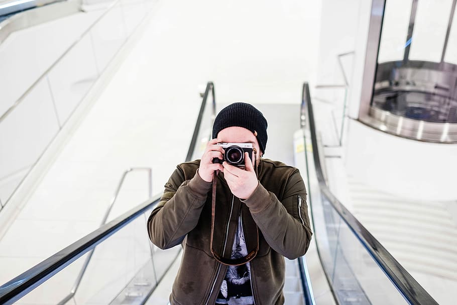 man holding SLR camera on escalator, outdoors, men, people, one Person HD wallpaper