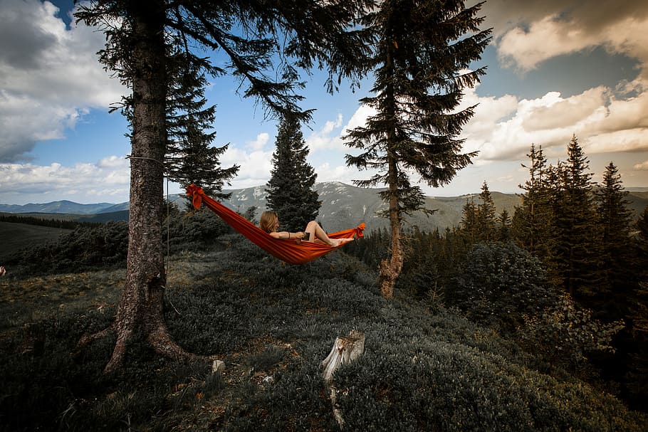 person lying on red hammock, red hammock in the middle of trees HD wallpaper