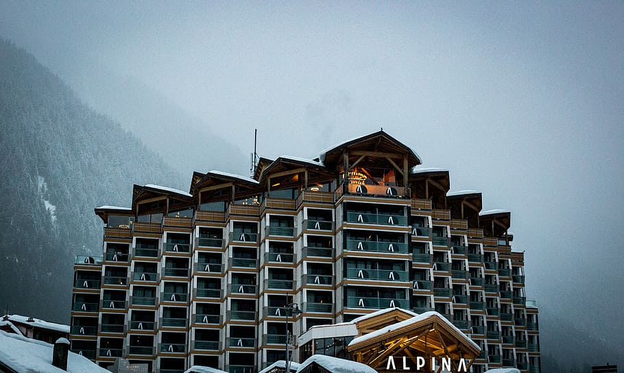 shallow focus photography of brown and black concrete structure near mountains, brown and blue painted building HD wallpaper