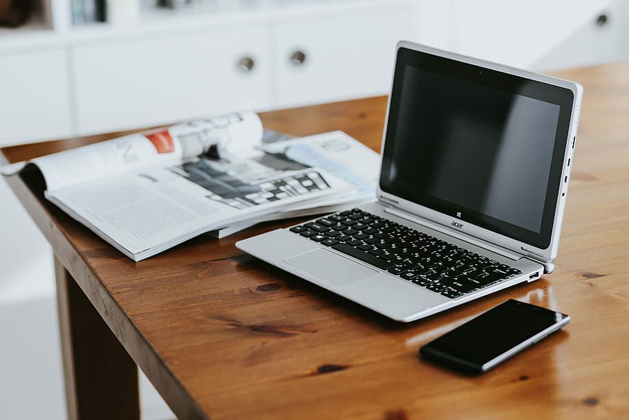 Silver laptop with various items on a table, magazines, computer HD wallpaper