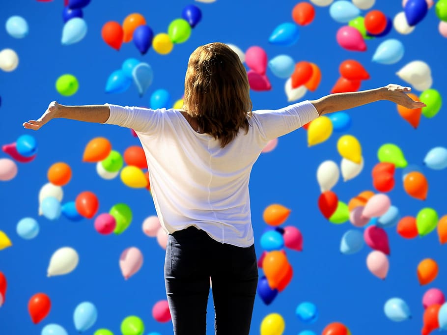 woman in white blouse under assorted-color balloons, say yes to the live