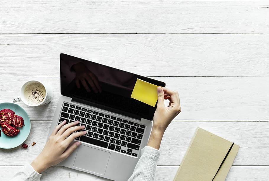 person typing on laptop while placing yellow sticky note on laptop monitor, HD wallpaper