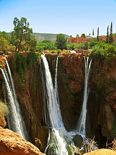 waterfalls near concrete building at daytime, ouzoud, morocco HD wallpaper