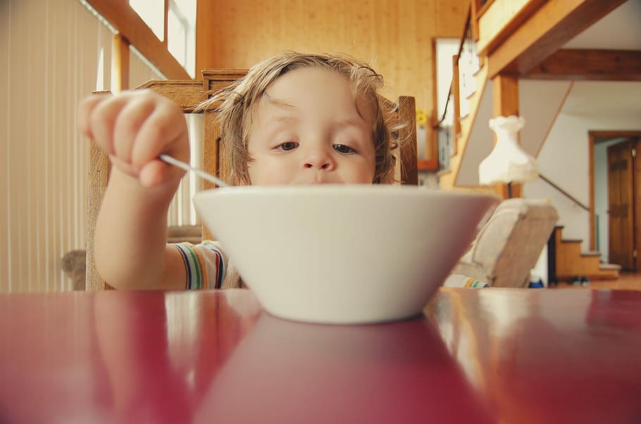round white ceramic bowl on red wooden table, baby in front of white bowl on red surface HD wallpaper