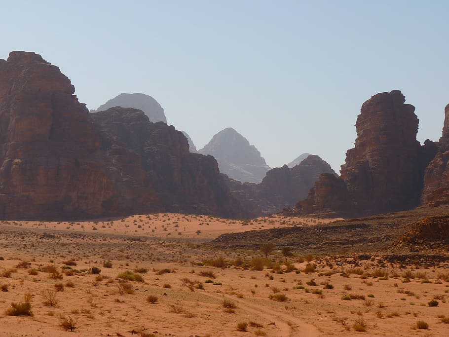 brown and grey rock formation landscape surrounded by beige sands