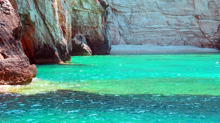 green-tinted clear body of water near brown cliffs, rock, sea
