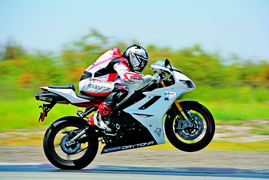 panning photography of person riding white sport bike, motorcycle