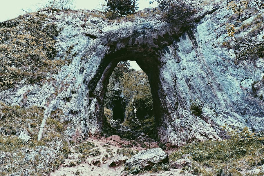 green grass covered rock formation at daytime, photo of cave during daytime HD wallpaper