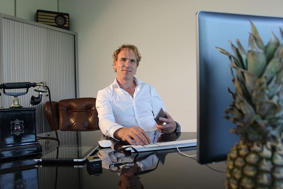 man sitting and working on his desk with computer, office, pineapple HD wallpaper