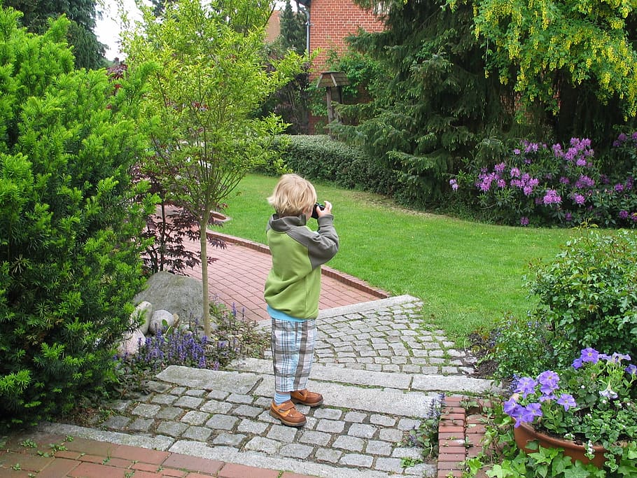 boy standing on brick pathway using camera, photographer, child
