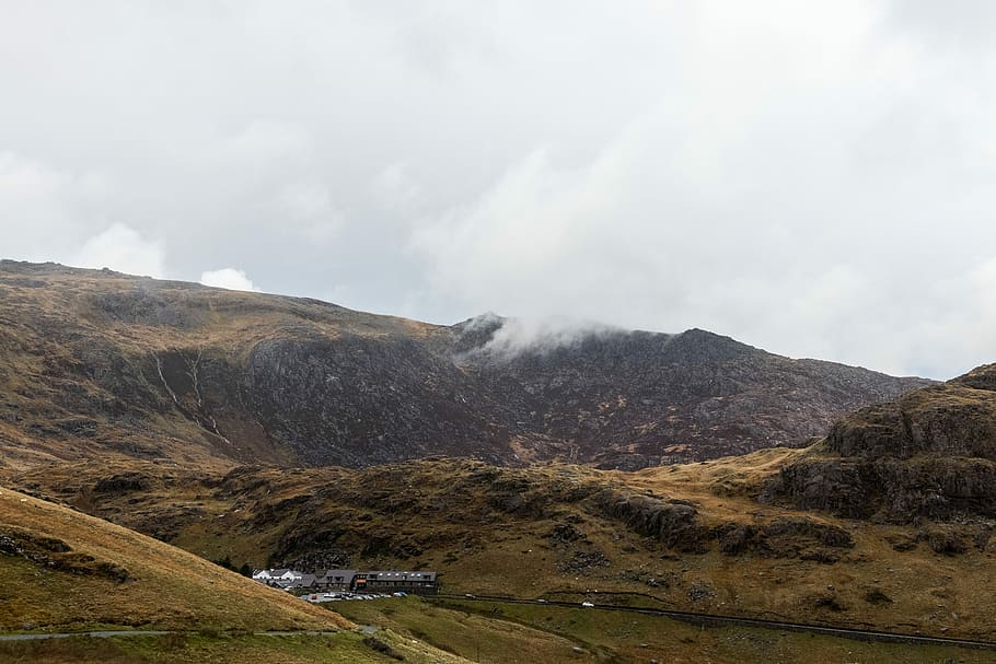 smokey mountain under white clouds, brown mountain near houses HD wallpaper