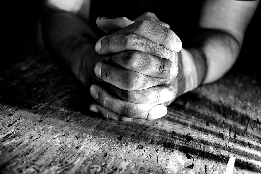 person holding both hands while leaning on surface greyscale photography HD wallpaper