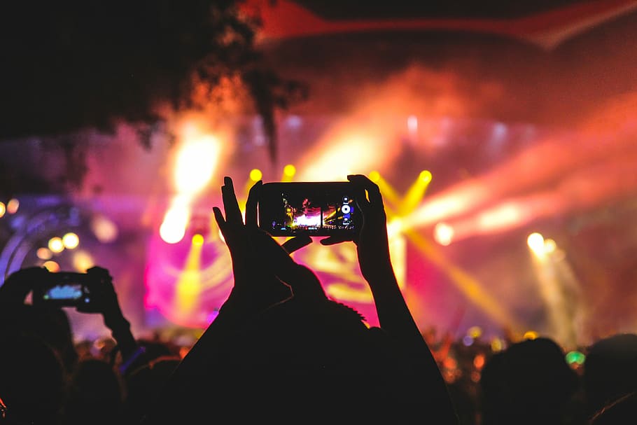 person holding smartphone taking video of a concert near stage with lights during nighttime, person holding smartphone showing disco lights HD wallpaper