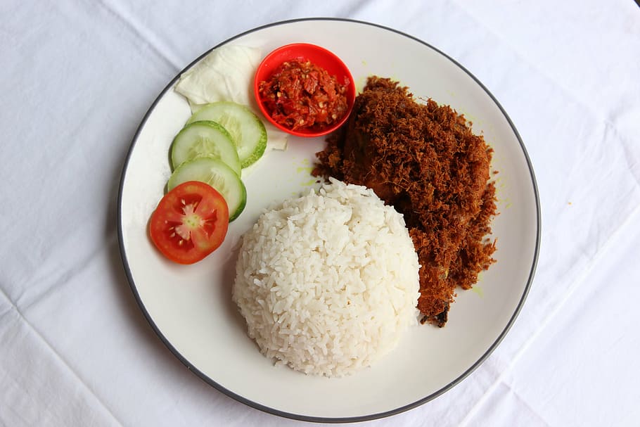 steamed rice, ground meat dish with tomato and cucumber slices in plate
