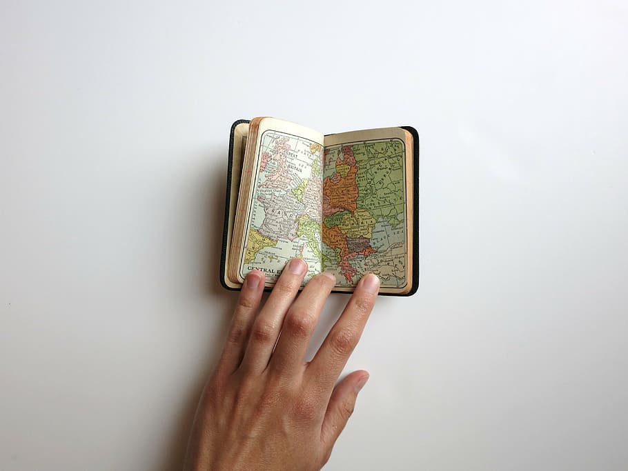 person opening a booklet of map, word, hand, travel, human hand HD wallpaper