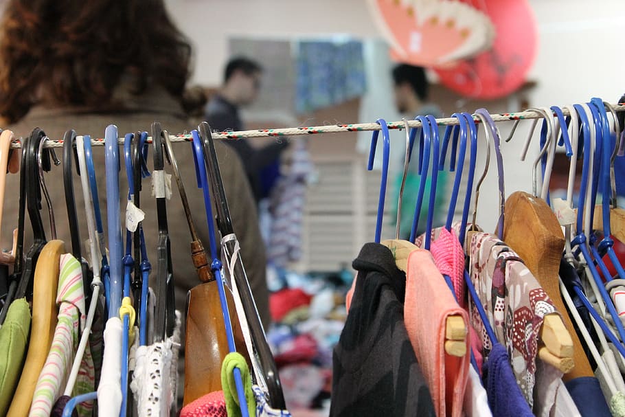 selective focus photo of hanged clothes, bazar, thrift store