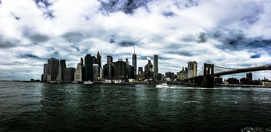 cityscape beside body of water under white cloudy sky at daytime HD wallpaper