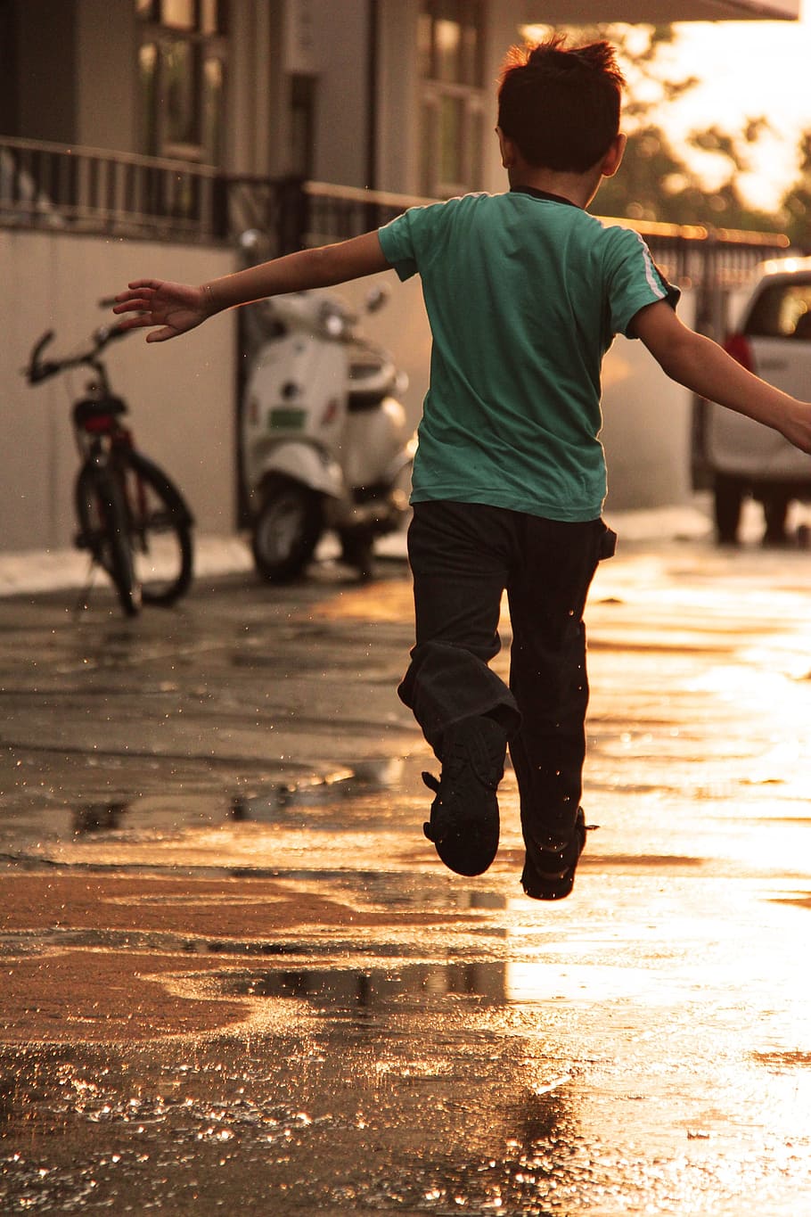 boy in teal t-shirt and black pants jumping on road, kid, enjoy