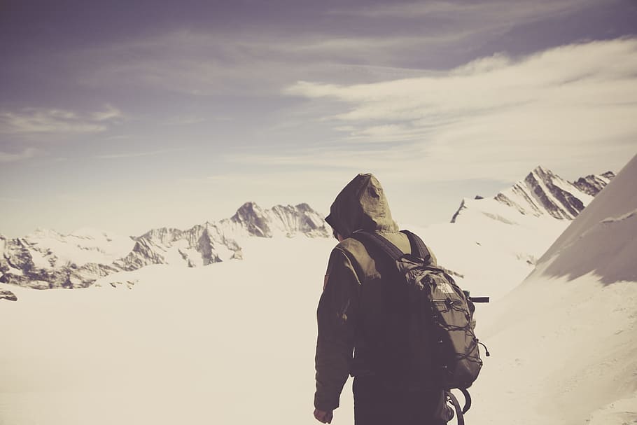 photo of person with hiking backpack on mountains filed with snow HD wallpaper