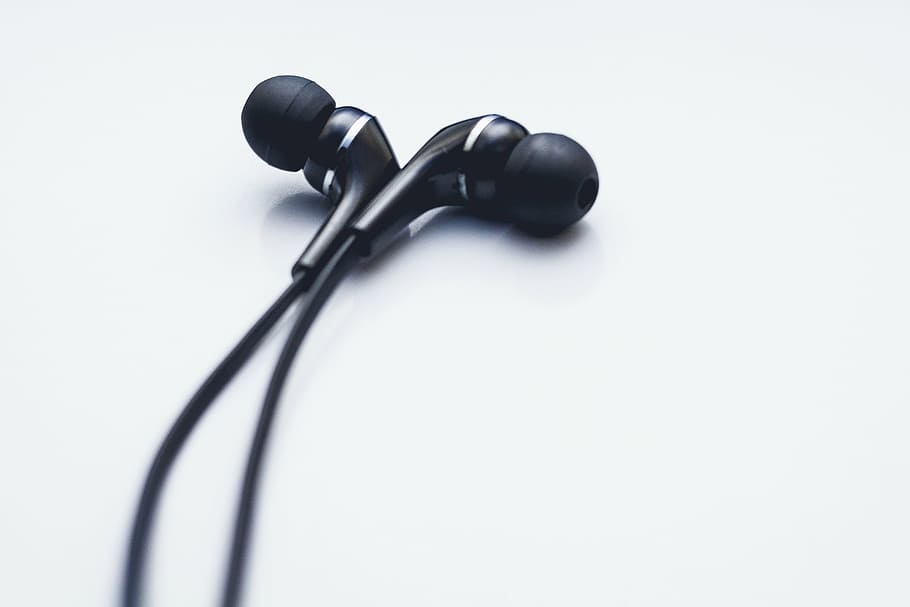 close-up photo of black earbuds, grey, earphones, cord, music