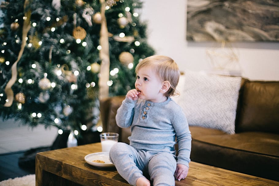 baby wearing gray long-sleeved shirt and pants sitting on brown wooden coffee table HD wallpaper