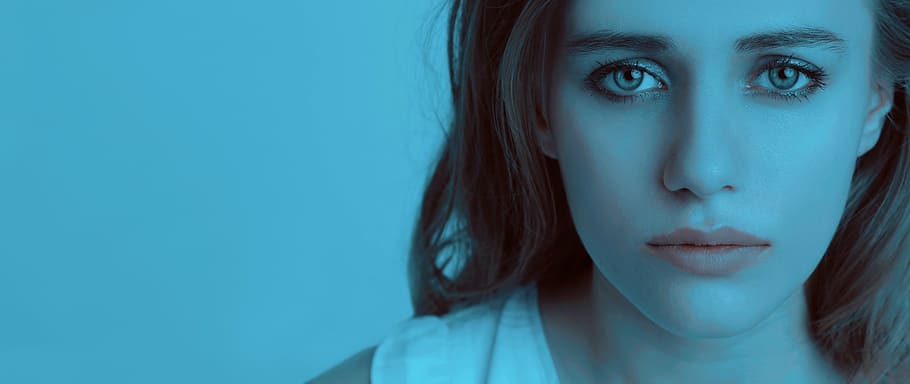 woman wearing white shirt with blue background, sad girl, girl crying