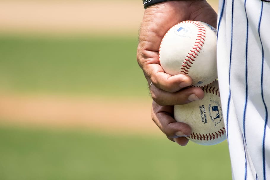 Entrenamiento Navegantes del Magallanes, man holding two baseballs standing in baseball stadium HD wallpaper