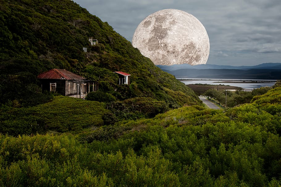 house on cliff and moon at distance during daytime, supermoon