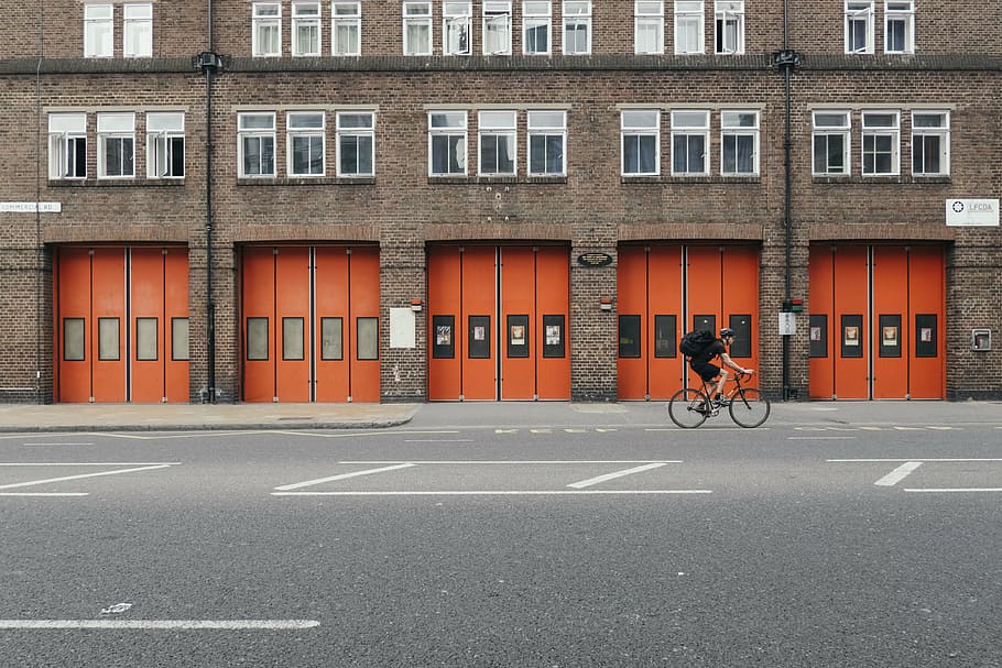 man riding bike near brown building at daytime, architecture HD wallpaper