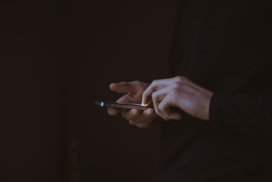silhouette photo of person holding smartphone, person using black iPhone 4