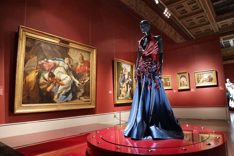 mannequin wearing red and blue dress near paintings, theatre