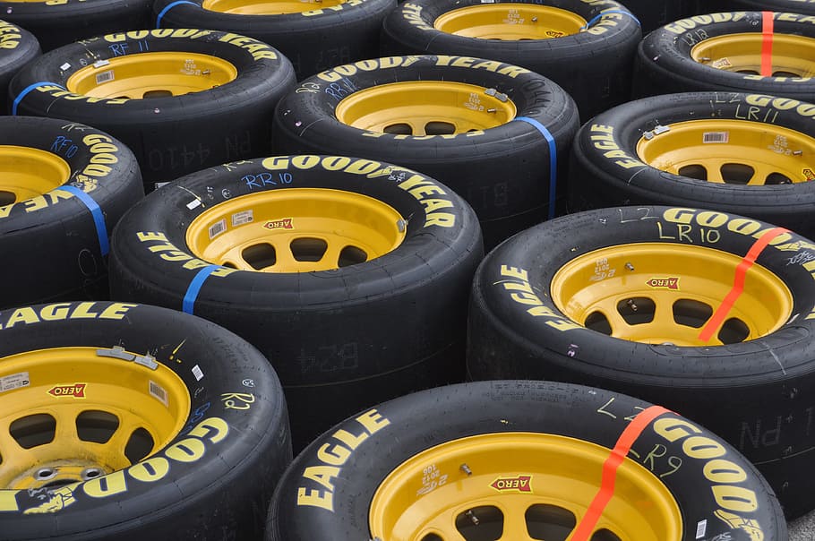close-up photography of yellow multi-spoke vehicle wheel and GoodYear tire lot