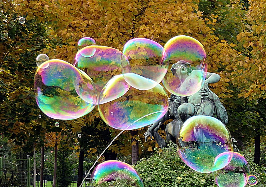 bubbles near gray concrete fountain and trees during daytime HD wallpaper