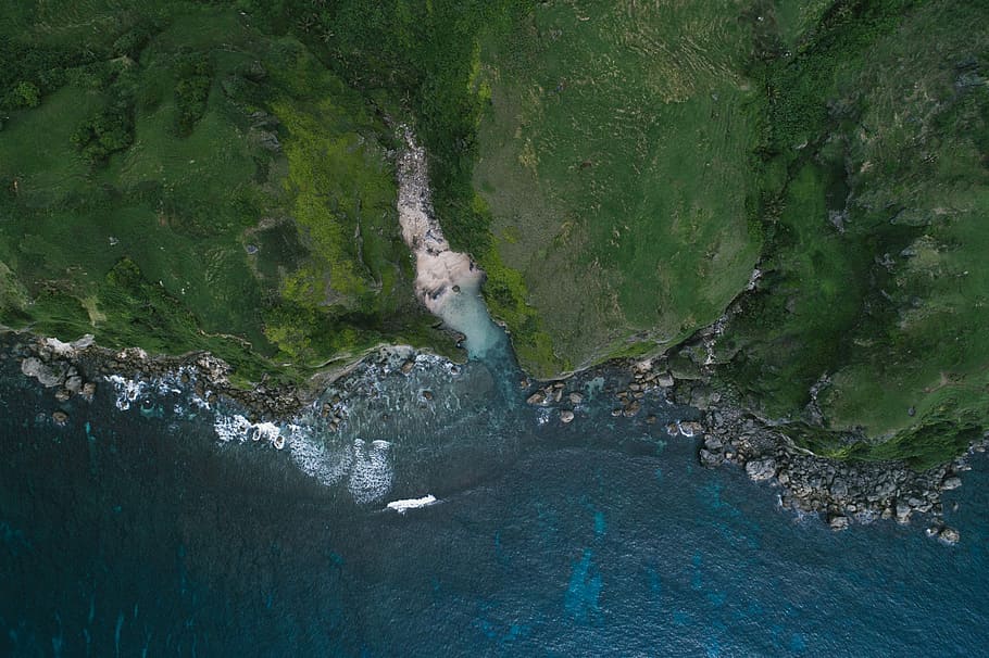 aerial photography of cliff, aerial view photography of mountain near body of water