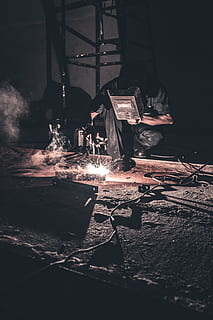man welding black metal, man holding welding mask while welding HD wallpaper