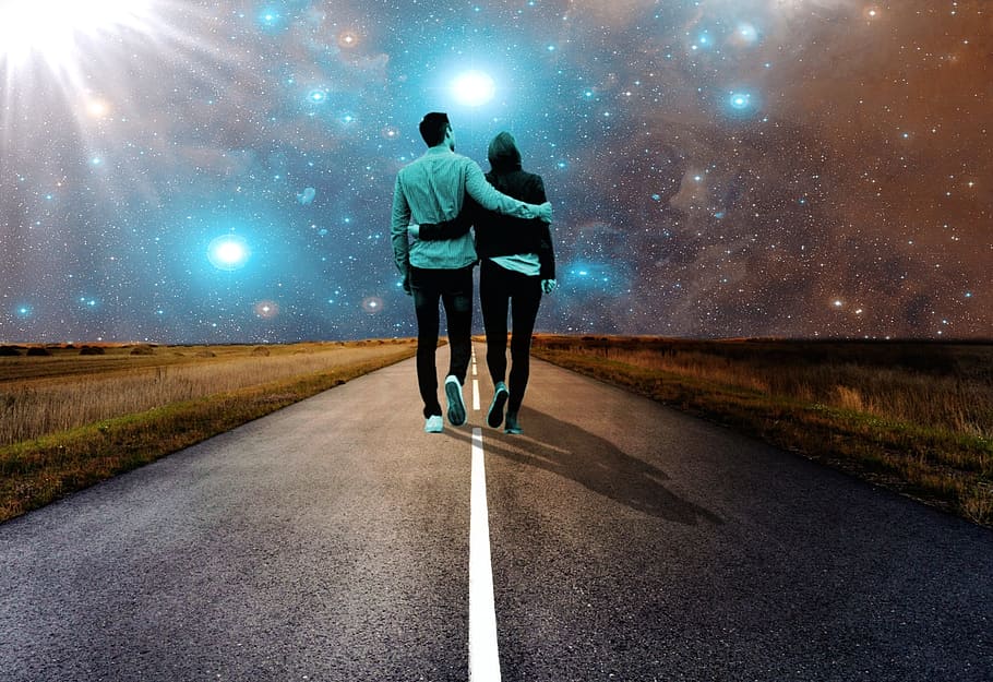 man and woman holding each other's arm walking towards road, asphalt