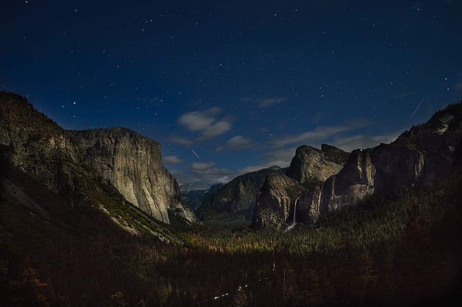 landscape photography of mountain and forest, mountain surrounded by trees during nighttime HD wallpaper